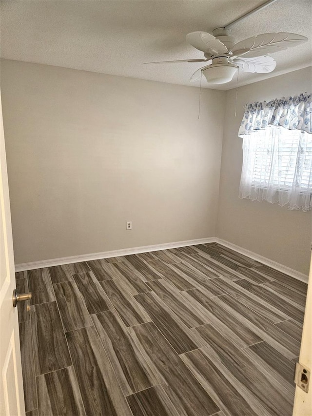 unfurnished room with ceiling fan, dark hardwood / wood-style floors, and a textured ceiling