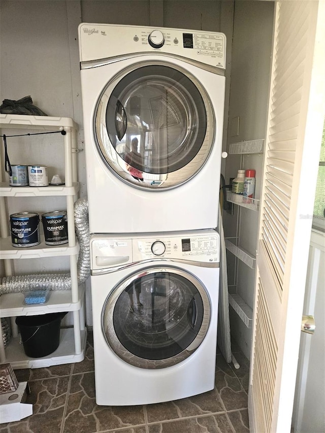 clothes washing area featuring stacked washer and clothes dryer