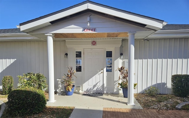 entrance to property featuring roof with shingles and board and batten siding