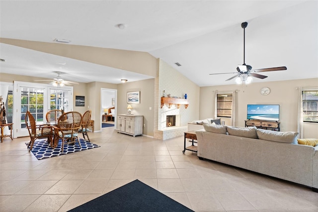 tiled living room featuring a healthy amount of sunlight, ceiling fan, a fireplace, and vaulted ceiling