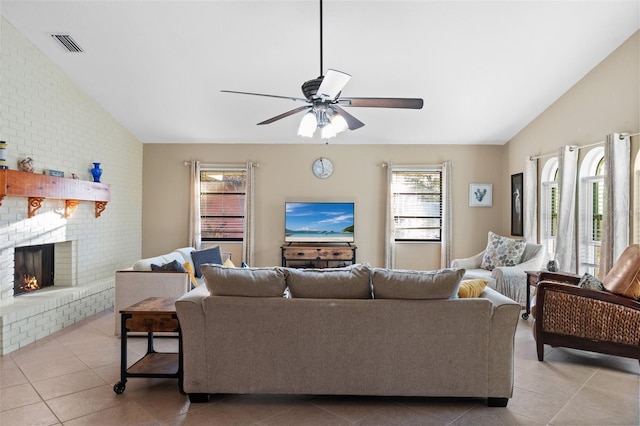 tiled living room featuring ceiling fan, lofted ceiling, and a brick fireplace