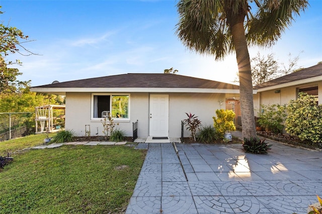 back of property with a patio and a lawn