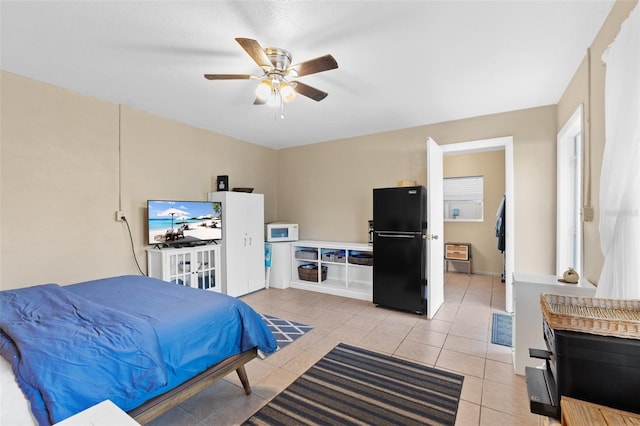 tiled bedroom featuring ceiling fan and black fridge