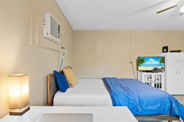 bedroom featuring a wall unit AC and ceiling fan