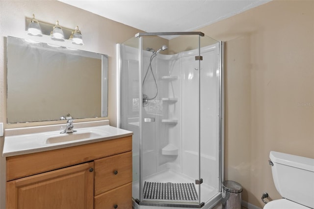 bathroom featuring a shower with door, toilet, and vanity