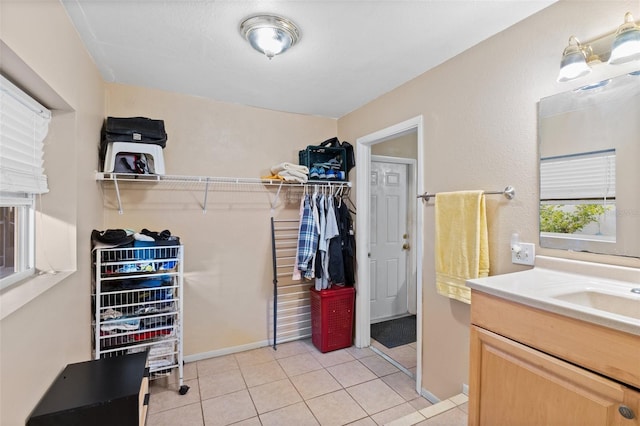 spacious closet with light tile patterned flooring and sink