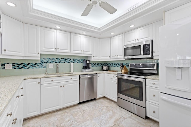 kitchen featuring sink, white cabinets, stainless steel appliances, and a tray ceiling