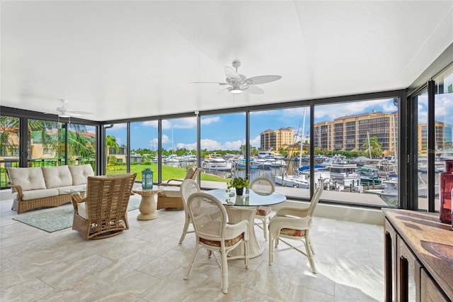 sunroom featuring a water view, a healthy amount of sunlight, and ceiling fan