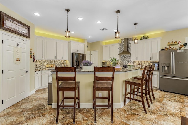 kitchen with wall chimney range hood, stainless steel fridge, white cabinets, and a center island