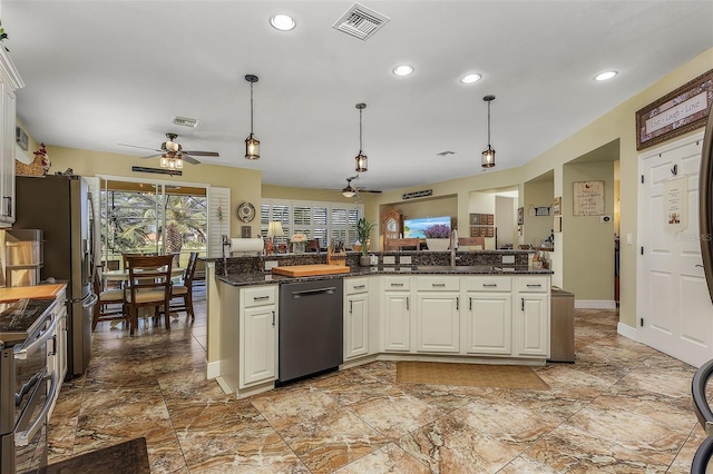 kitchen with hanging light fixtures, ceiling fan, stainless steel dishwasher, white cabinets, and dark stone countertops