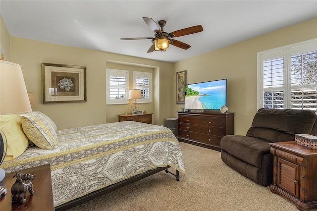 bedroom featuring multiple windows, light colored carpet, and ceiling fan