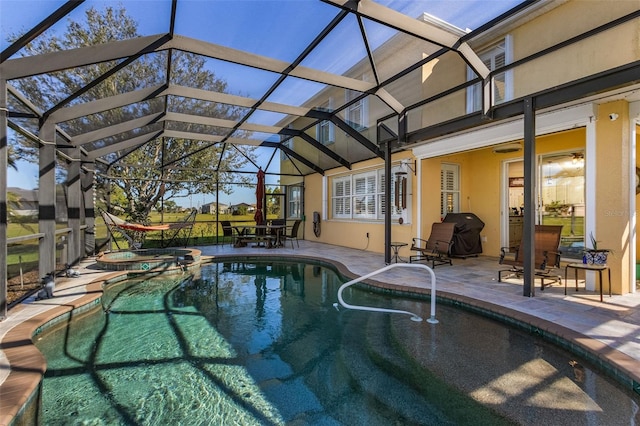 view of swimming pool with an in ground hot tub, a patio area, and glass enclosure