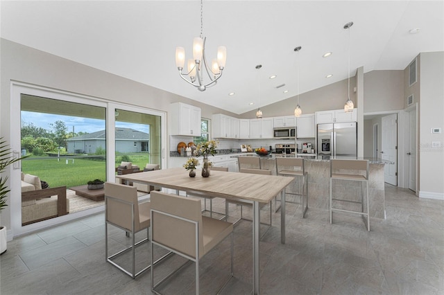 dining area featuring an inviting chandelier and high vaulted ceiling