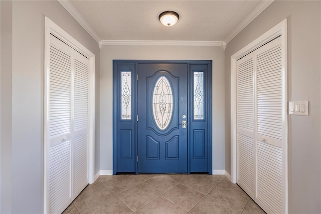 tiled foyer entrance featuring crown molding and a textured ceiling