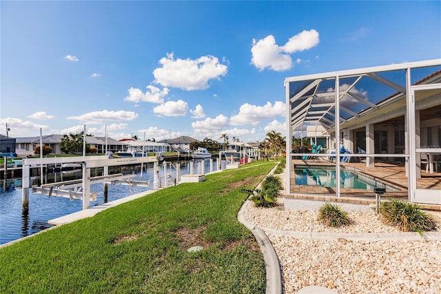 dock area with a patio, a yard, a water view, and a lanai