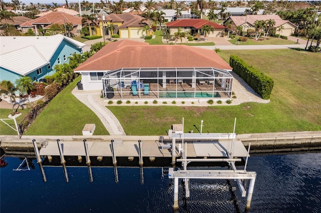 rear view of property with a patio, a lanai, a yard, and a water view