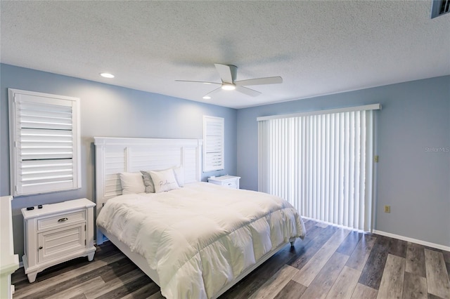 bedroom with a textured ceiling, dark hardwood / wood-style floors, and ceiling fan