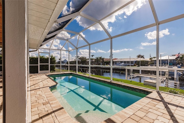 view of swimming pool featuring a water view, a patio, a lanai, and a boat dock