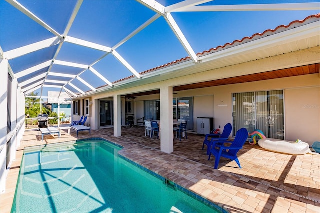 view of swimming pool featuring a grill, a patio, and a lanai