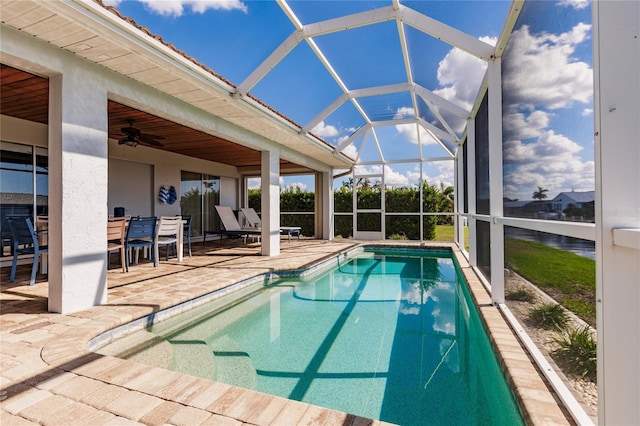 view of swimming pool featuring a patio, glass enclosure, and ceiling fan