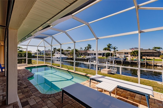 view of pool with a patio area, a boat dock, a water view, and glass enclosure