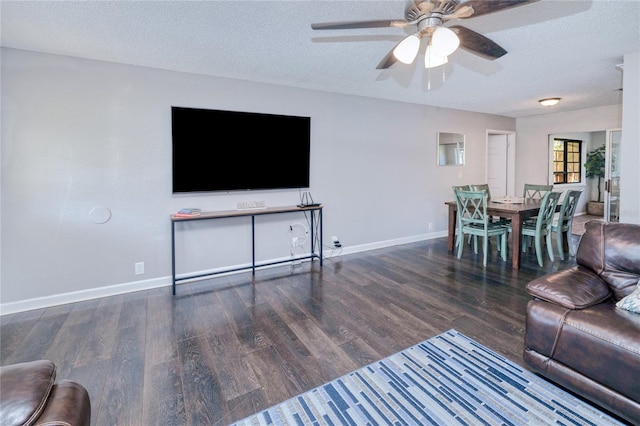 living room with a textured ceiling and dark hardwood / wood-style floors