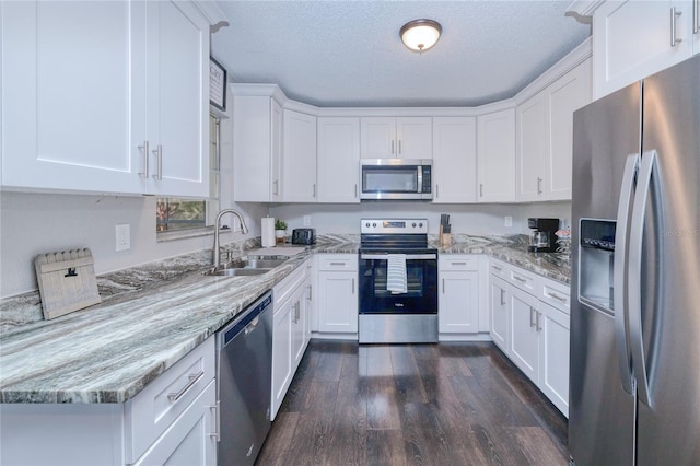 3173 S Cranberry Blvd, North Port, FL 34286 - kitchen with stainless steel appliances, a sink, dark wood-type flooring, white cabinetry, and light stone countertops