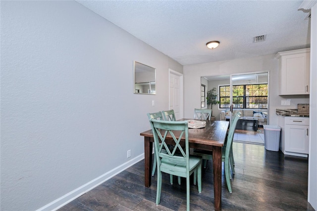 dining area with dark hardwood / wood-style floors and a textured ceiling