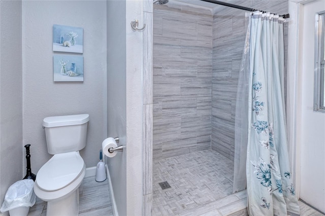 bathroom featuring toilet and curtained shower