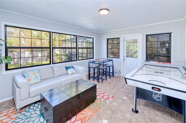 living room featuring crown molding, a textured ceiling, plenty of natural light, and light tile patterned floors