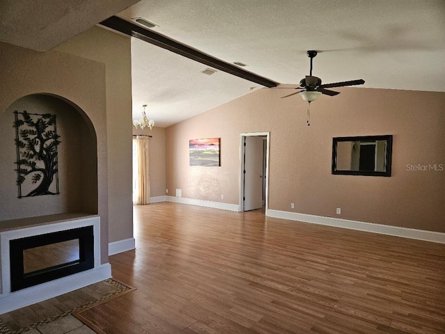 unfurnished living room featuring a textured ceiling, lofted ceiling with beams, ceiling fan with notable chandelier, and hardwood / wood-style flooring