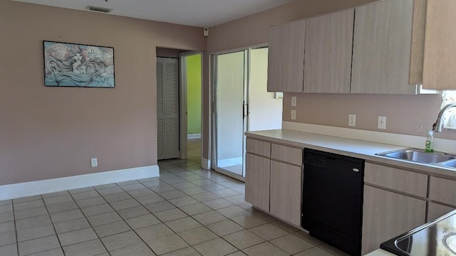 kitchen with black dishwasher, light brown cabinets, sink, and light tile patterned floors