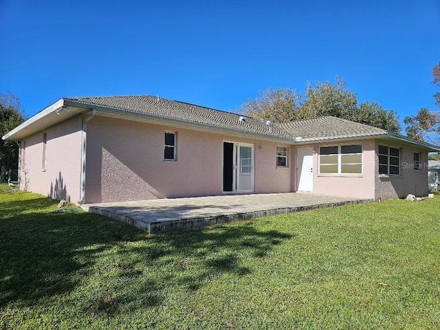 back of property with a patio area and a yard