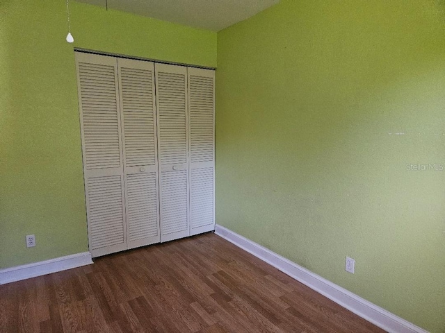 unfurnished bedroom featuring hardwood / wood-style floors and a closet