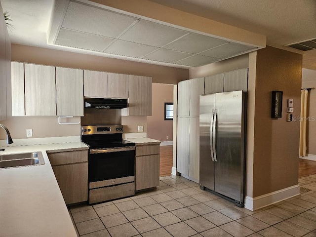 kitchen featuring stainless steel appliances, light tile patterned floors, and sink