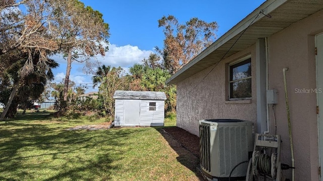 view of yard featuring a shed and central AC