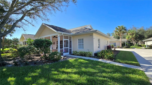 view of side of property featuring a sunroom and a lawn