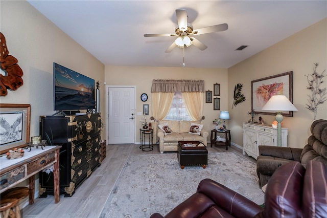 living room with light hardwood / wood-style floors and ceiling fan