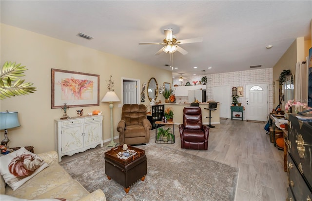 living room featuring ceiling fan and light wood-type flooring