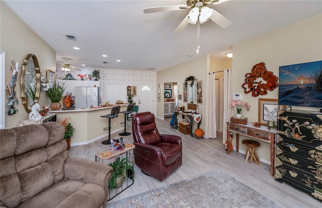 living room with light hardwood / wood-style floors and ceiling fan