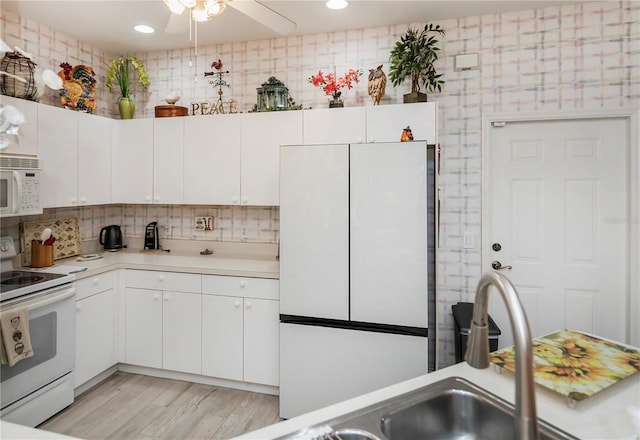 kitchen with ceiling fan, light wood-type flooring, white cabinetry, white appliances, and tasteful backsplash