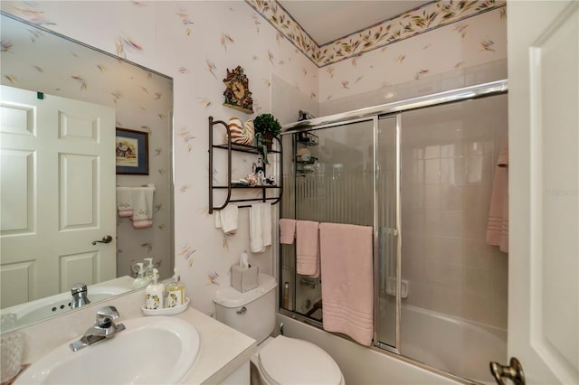 full bathroom featuring toilet, bath / shower combo with glass door, and vanity