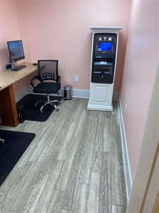 office with built in desk and light wood-type flooring