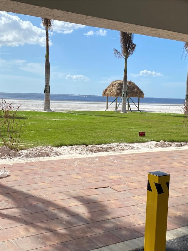 view of patio / terrace with a water view and a view of the beach