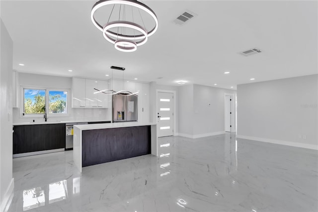 kitchen with white cabinets, dark brown cabinets, stainless steel appliances, a notable chandelier, and sink