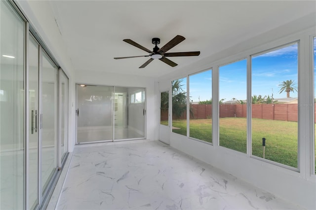 unfurnished sunroom featuring ceiling fan