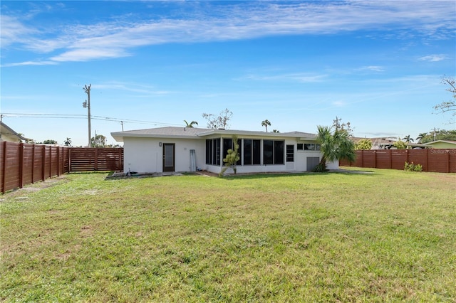 rear view of property featuring a lawn and a sunroom