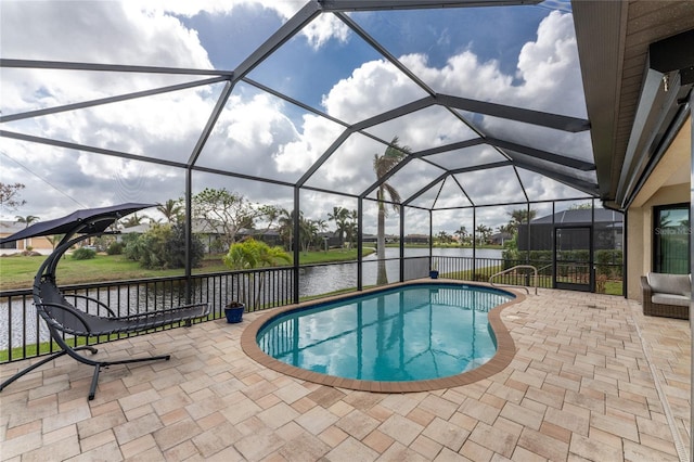 view of pool with a water view, glass enclosure, and a patio