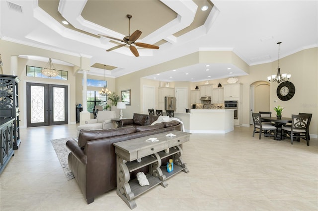 living room featuring a raised ceiling, french doors, and ornamental molding