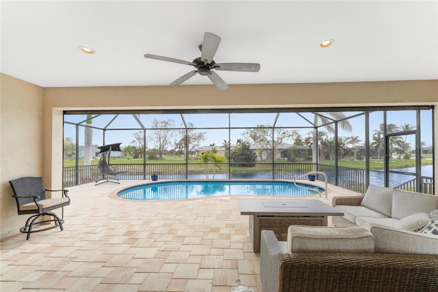 view of pool with a patio area, an outdoor living space, a water view, a lanai, and ceiling fan